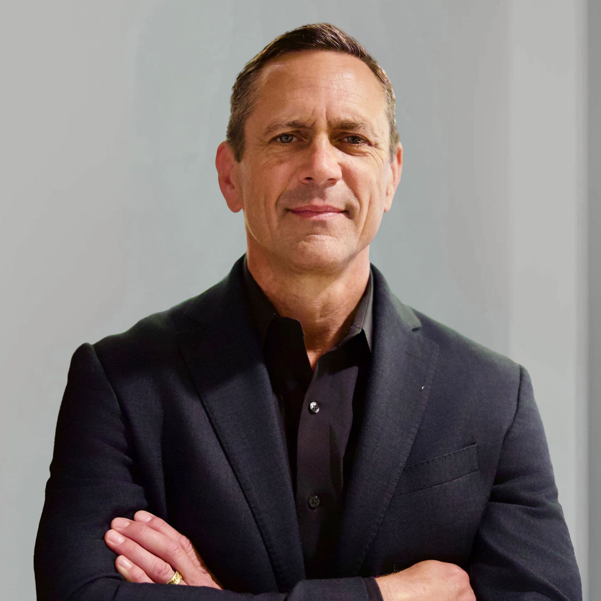 Man with arms crossed in a business suit